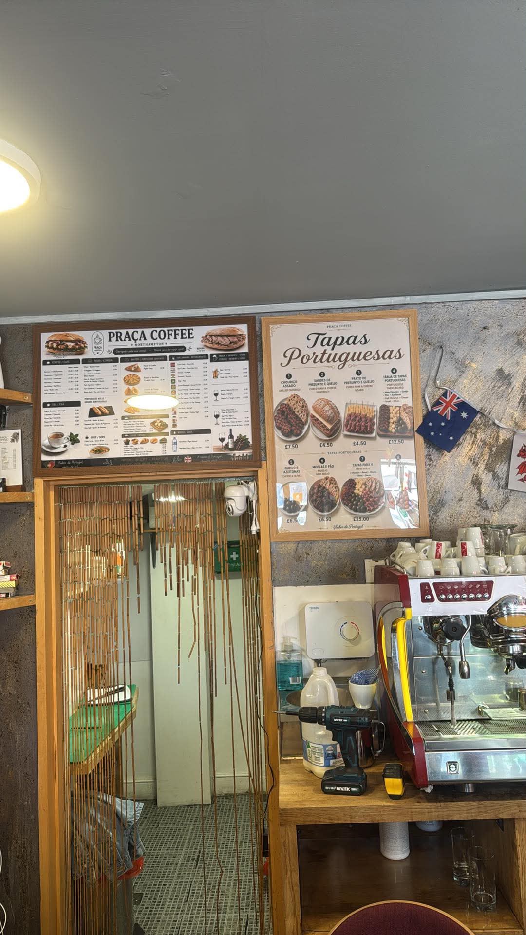 Interior do Praça com os quadros do menu e a máquina de café